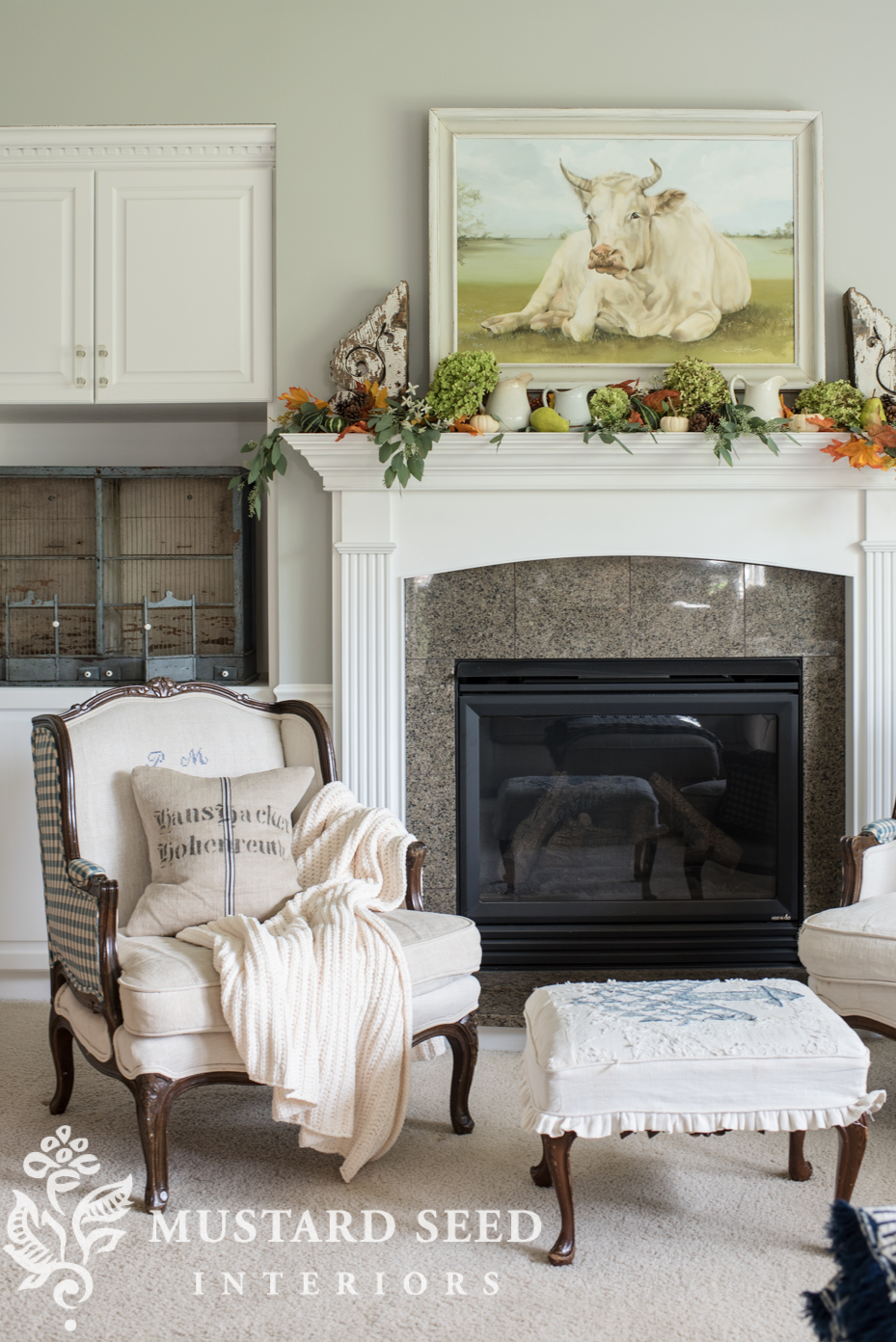 Decorating for fall on our mantel using fall leaf garland with berries and mini pumpkins, chunky blanket. | missmustardseed.com