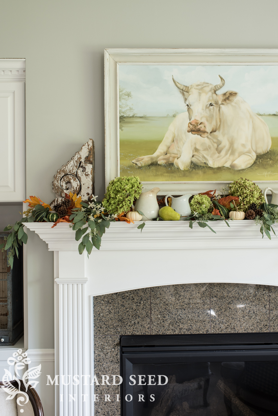Decorating for fall on our mantel using fall leaf garland with berries and mini pumpkins. | missmustardseed.com