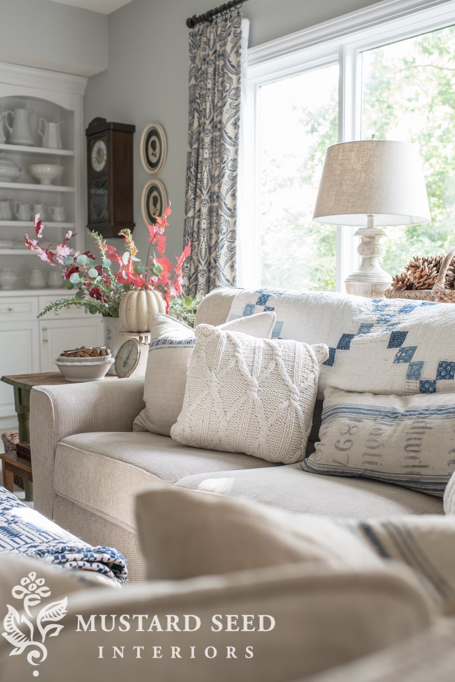 Decorating for fall in living room, faux pumpkin, fall branches, knit pillow. | missmustardseed.com