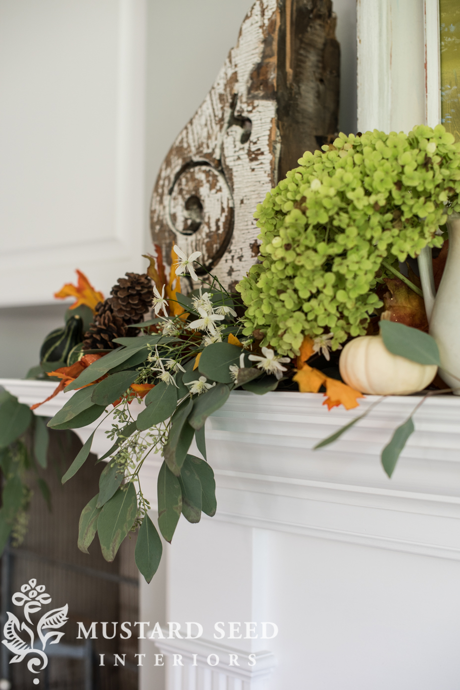 Decorating for fall on our mantel using fall leaf garland with berries and mini pumpkins. | missmustardseed.com