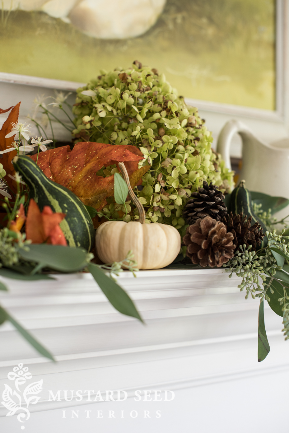 Decorating for fall on our mantel using fall leaf garland with berries and mini pumpkins. | missmustardseed.com