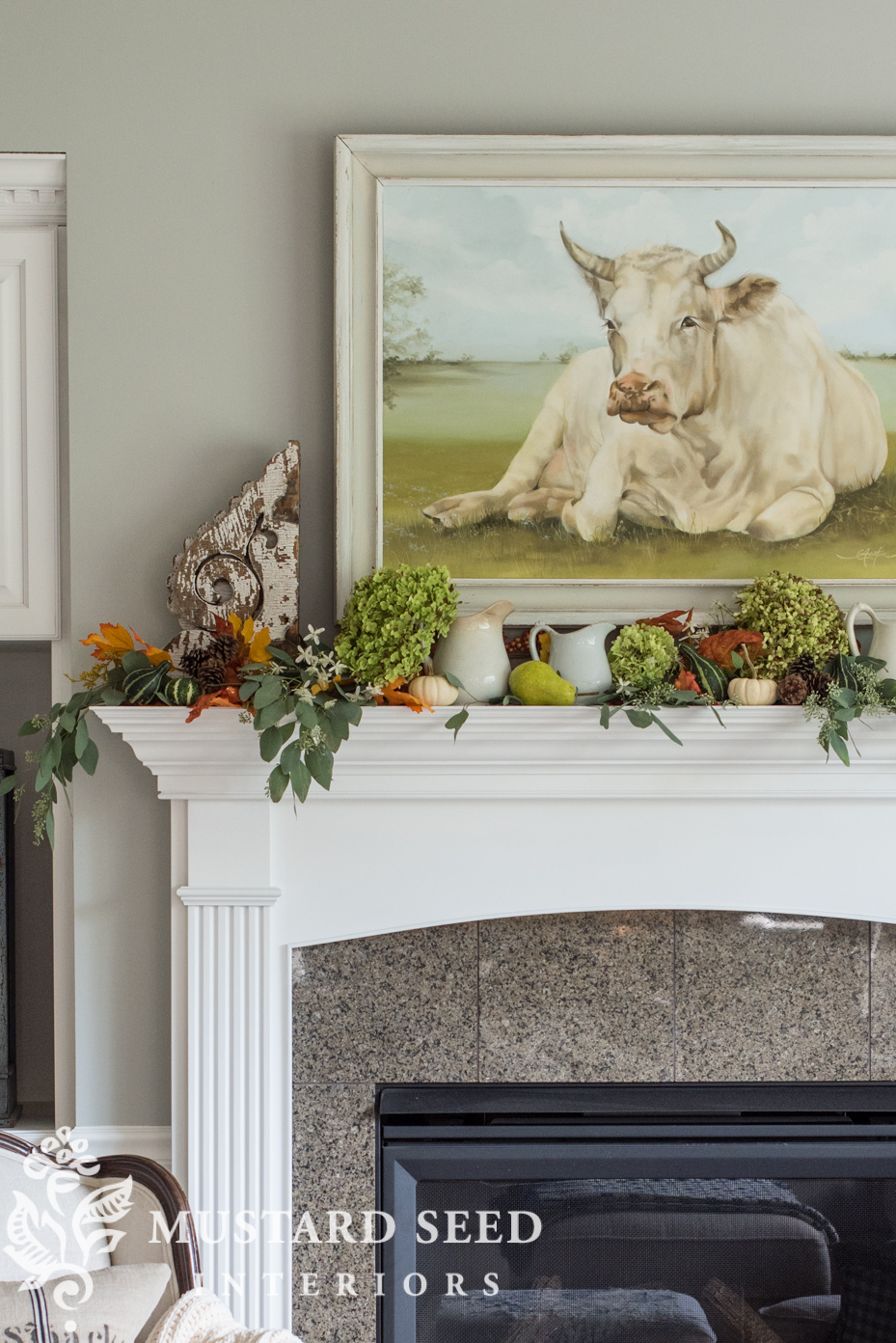 Decorating for fall on our mantel using fall leaf garland with berries and mini pumpkins. | missmustardseed.com