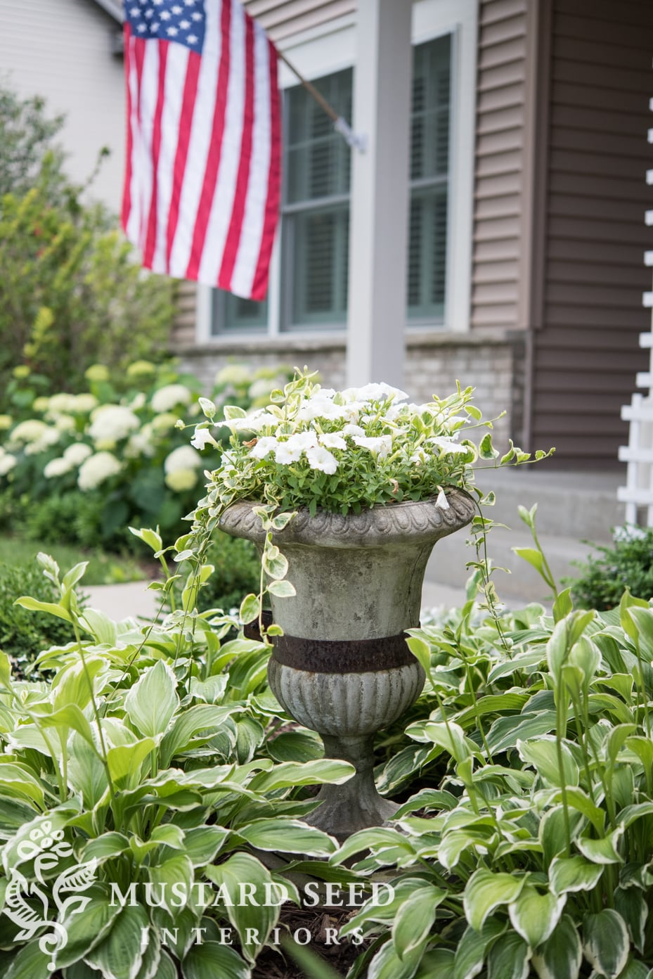 antique concrete urn with flowers and hostas | miss mustard seed